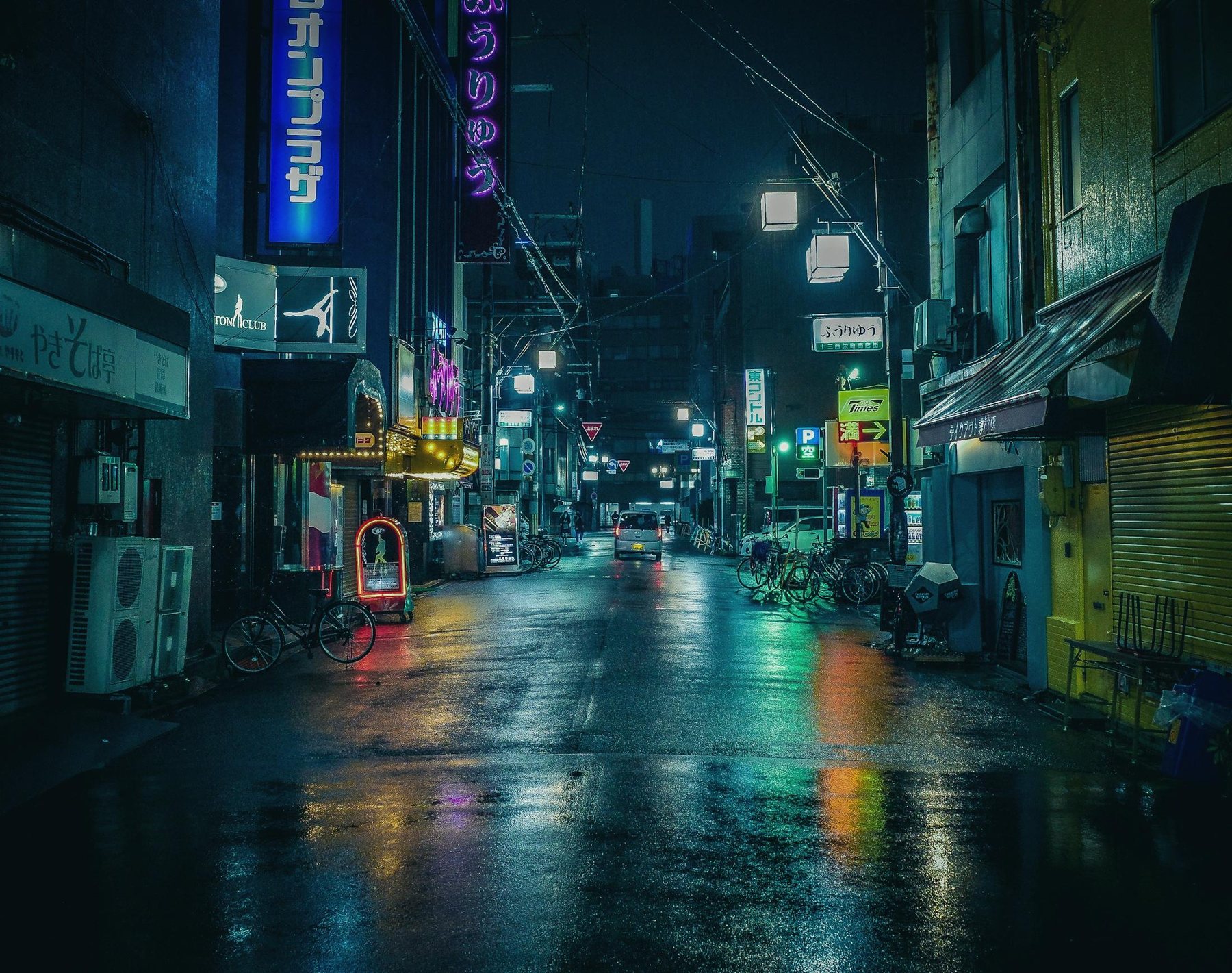 Fertig bearbeitete Nachtaufnahme einer nassen Straße in Osaka mit Leuchtreklamen